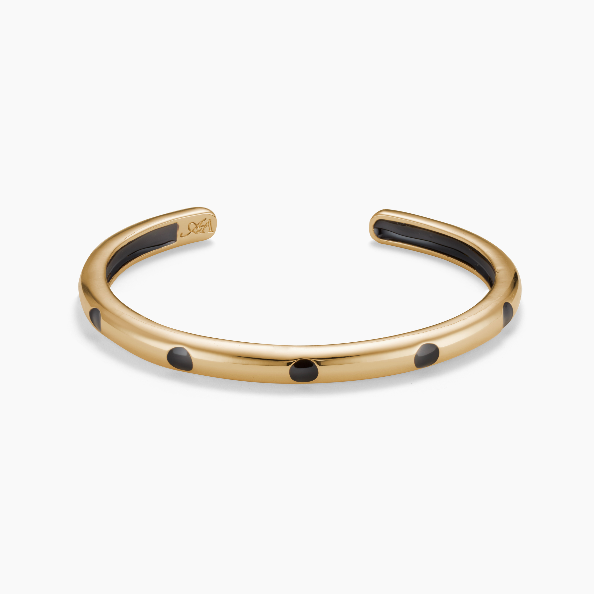 Gold bracelet with black dots on a white background