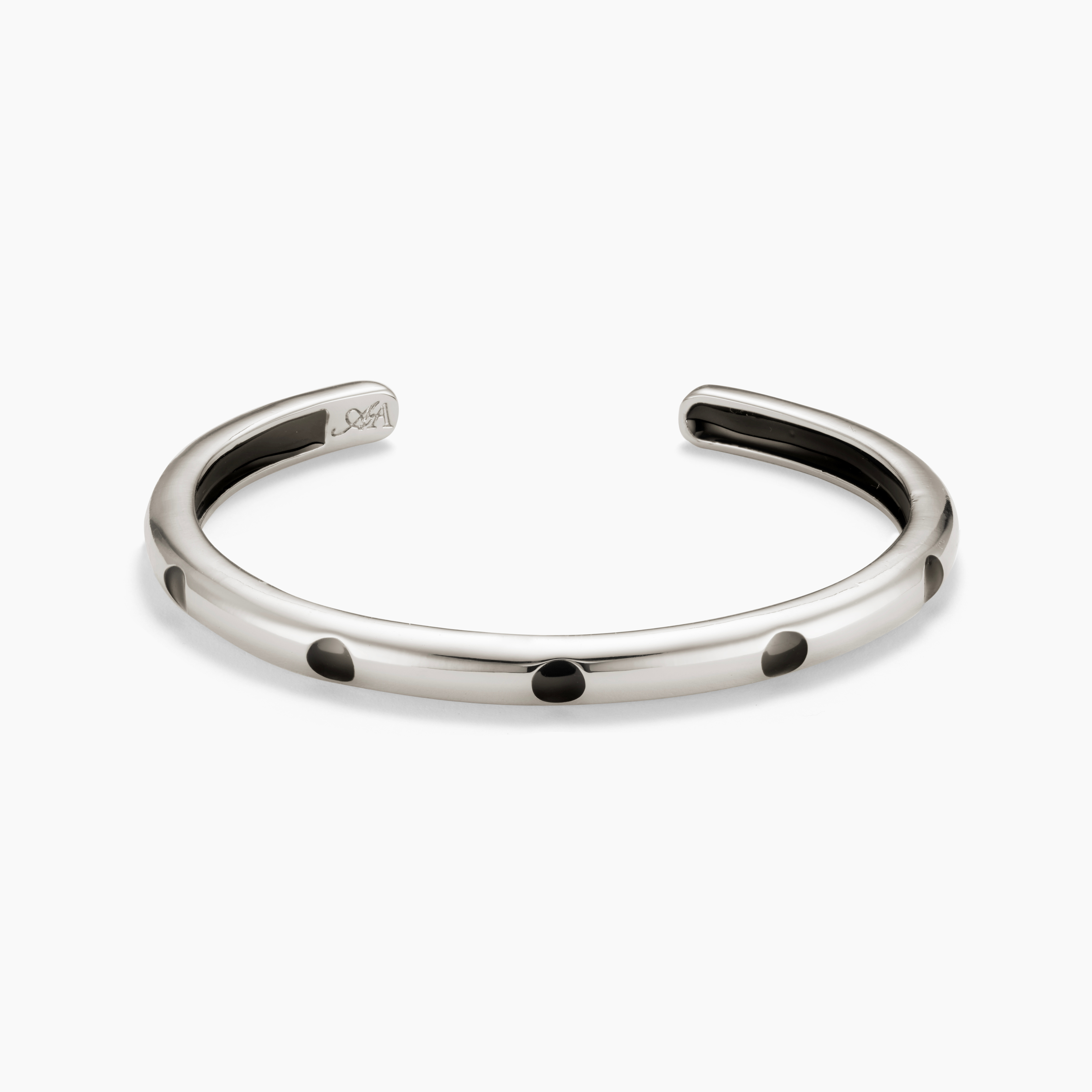 Silver bracelet with black dots on a white background