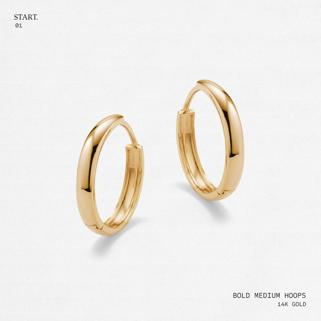 Gold hoop earrings on a light gray background