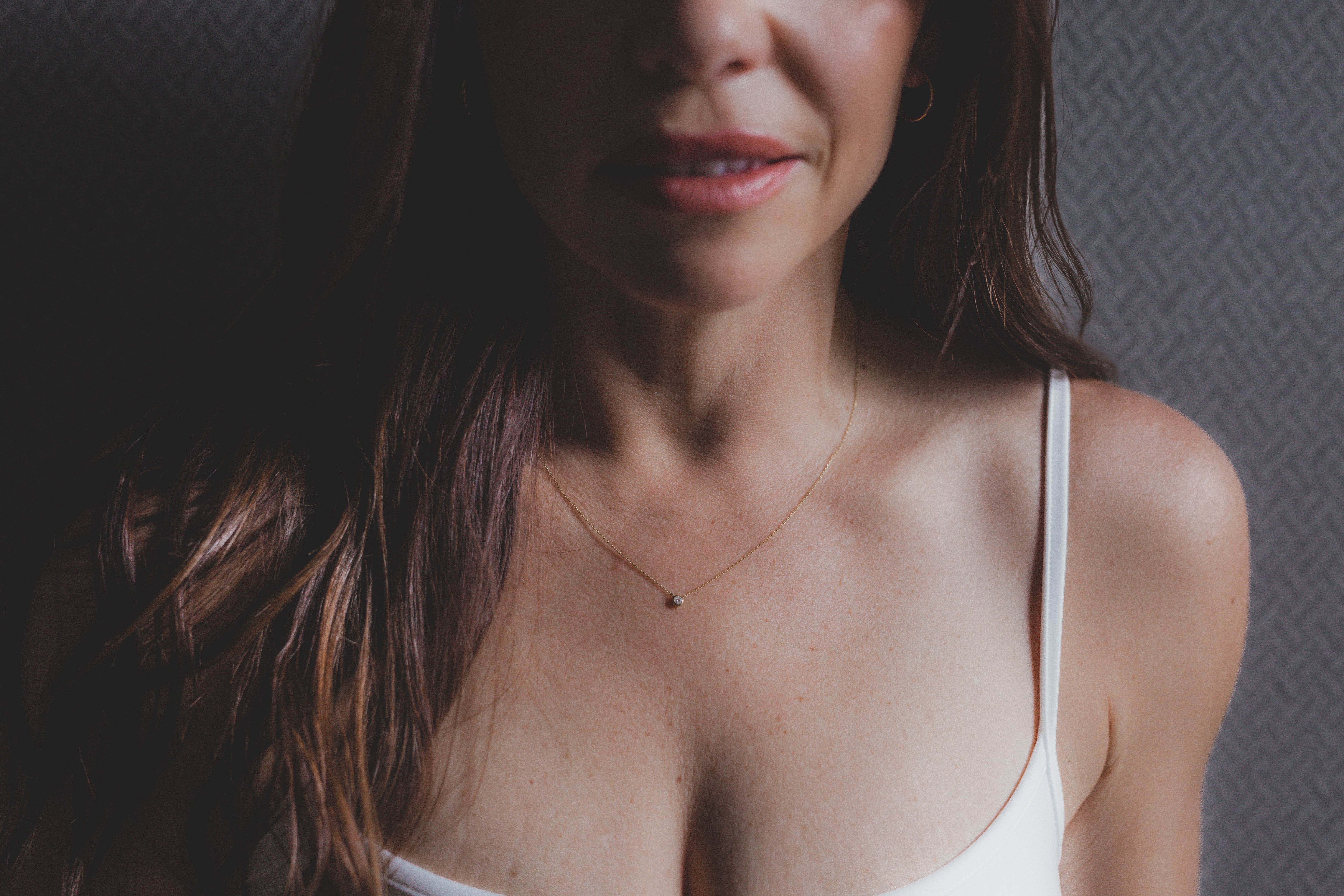 Woman wearing a white tank top with a neutral background with the Armine + Ambrose diamond necklace