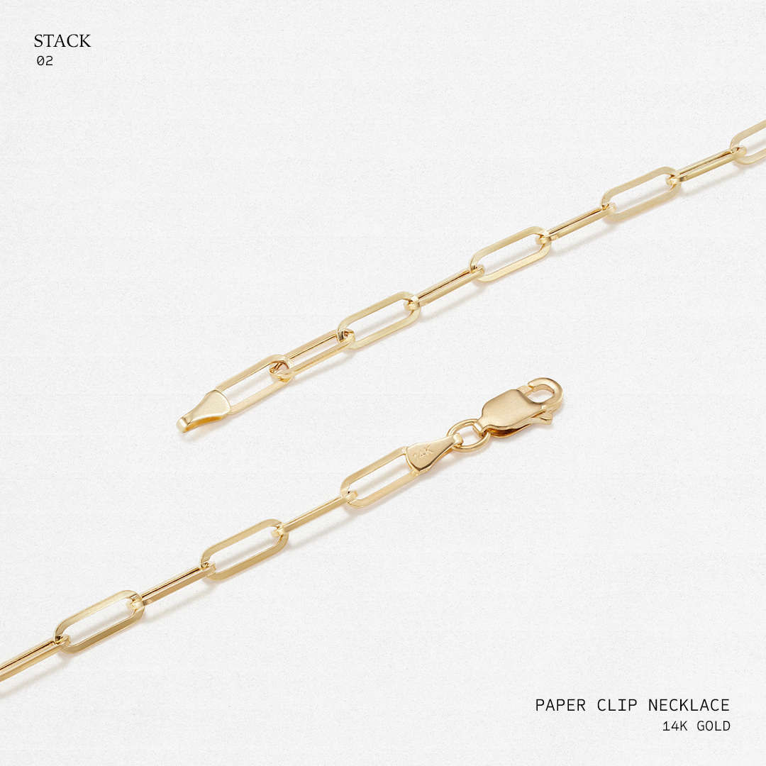 Gold paperclip necklace on a white background