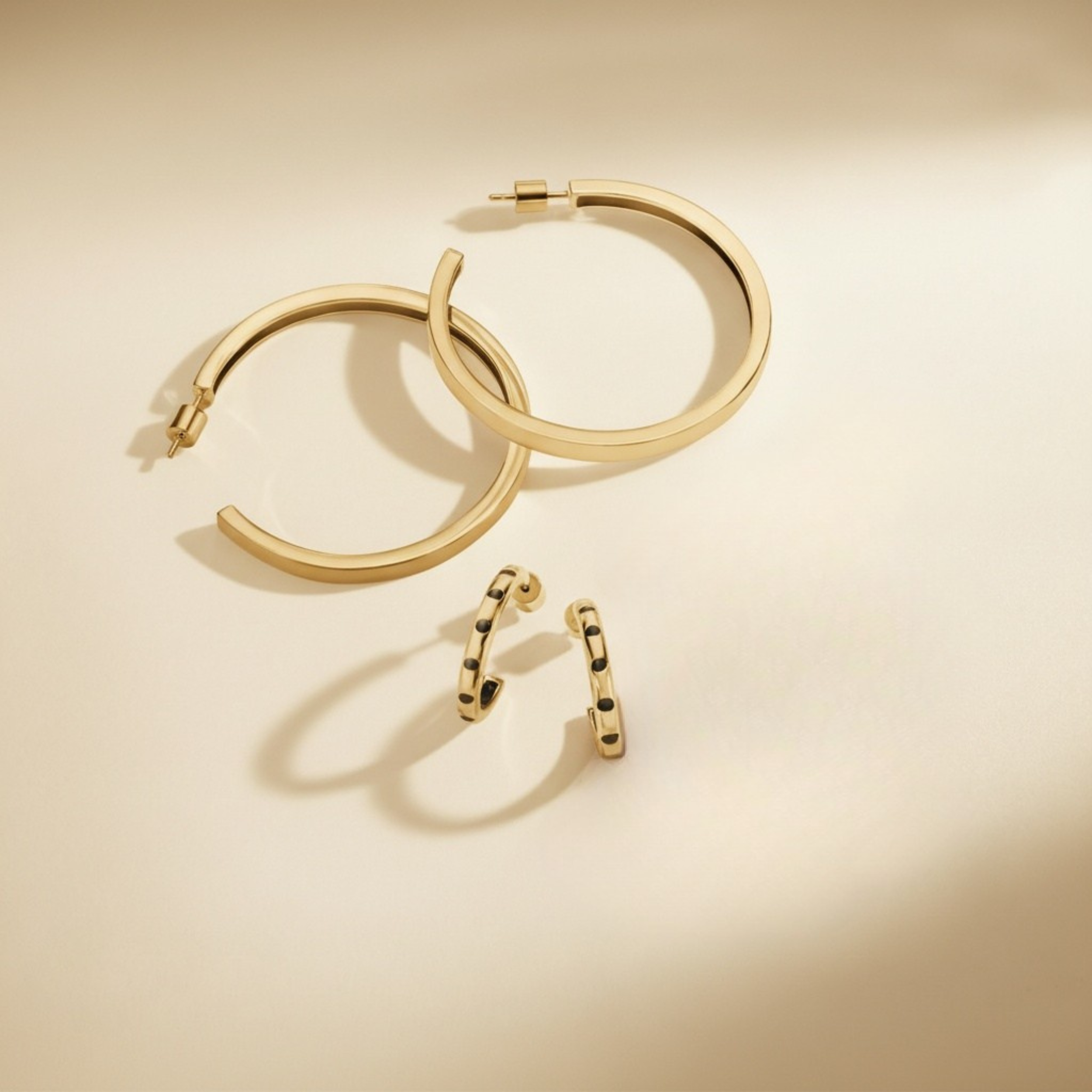 Gold hoop earrings on a beige background