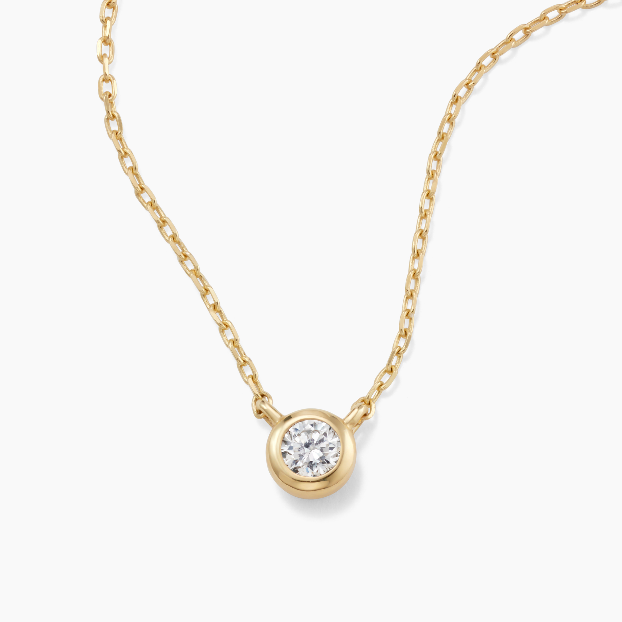 Gold necklace with a diamond pendant on a white background