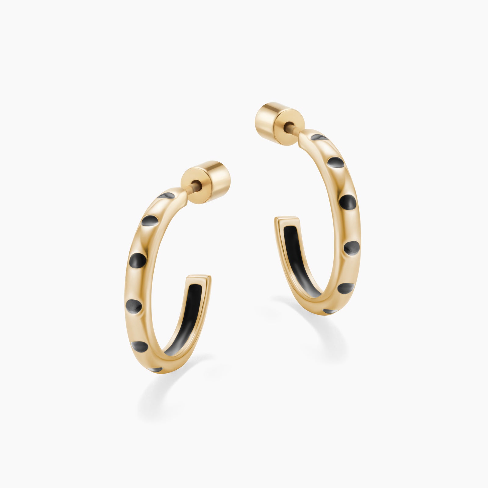 Gold hoop earrings with black dot accents on a white background